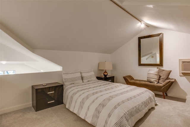 carpeted bedroom with a wall mounted AC, rail lighting, and vaulted ceiling