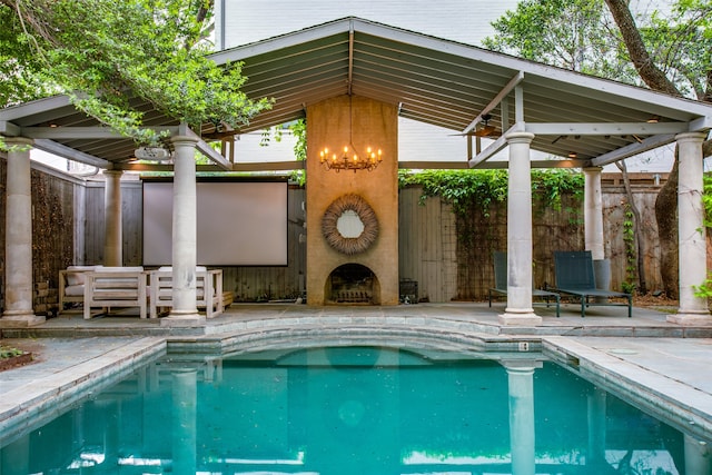 view of swimming pool with a gazebo, a fireplace, and a patio