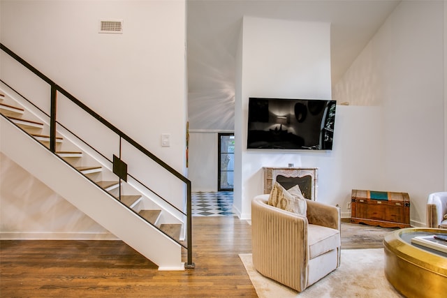 living room with hardwood / wood-style floors and a high ceiling