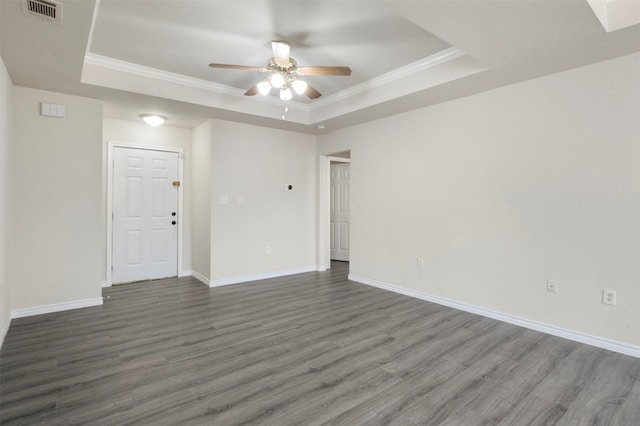 empty room with dark hardwood / wood-style floors, a raised ceiling, ceiling fan, and crown molding