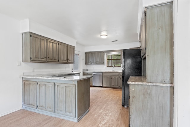 kitchen featuring black refrigerator, dishwasher, light hardwood / wood-style floors, and sink