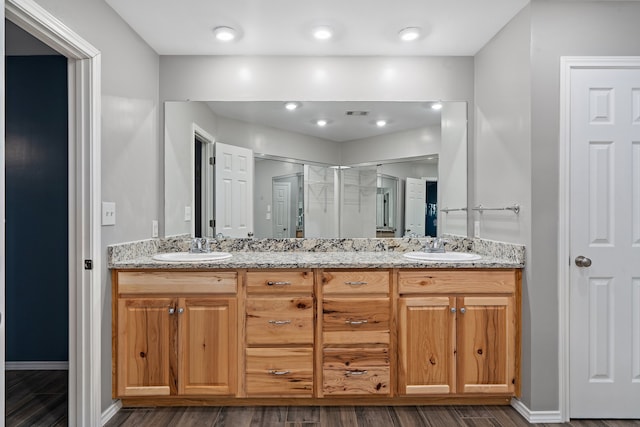 bathroom featuring a shower with door, vanity, and wood-type flooring