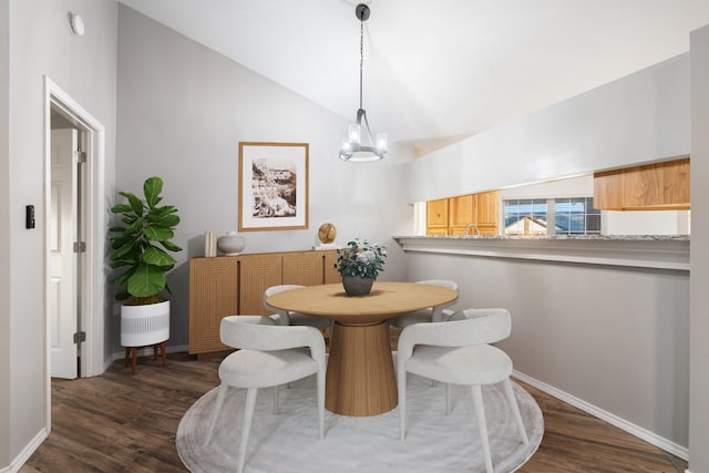 dining space featuring a chandelier, dark hardwood / wood-style flooring, and vaulted ceiling