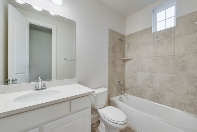 full bathroom with tiled shower / bath, vanity, and toilet