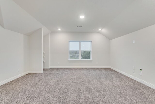 bonus room with lofted ceiling and carpet floors