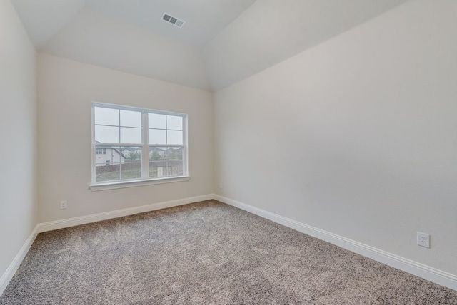 empty room with carpet flooring and vaulted ceiling