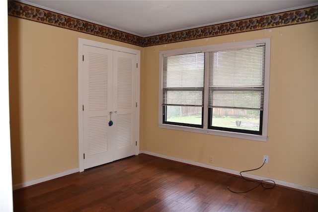 unfurnished bedroom with a closet and dark wood-type flooring