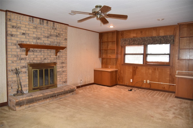 unfurnished living room with ceiling fan, light colored carpet, and a brick fireplace