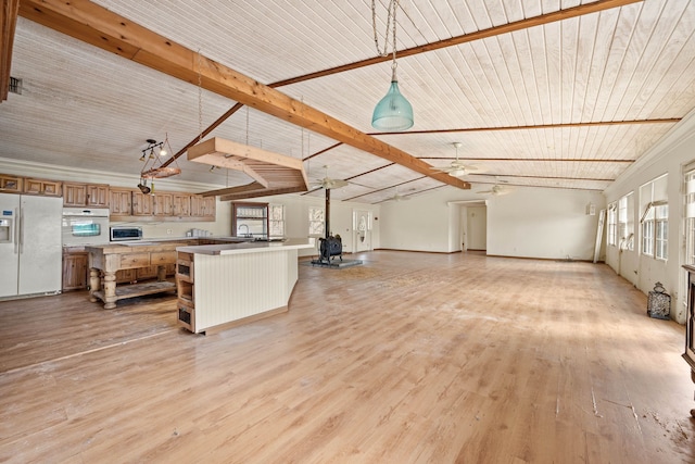 kitchen featuring lofted ceiling with beams, white appliances, light wood-style floors, open floor plan, and brown cabinets