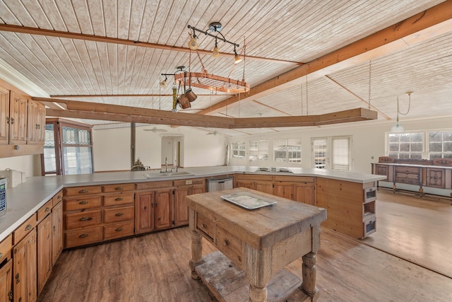 kitchen with wood ceiling, a sink, a peninsula, and wood finished floors