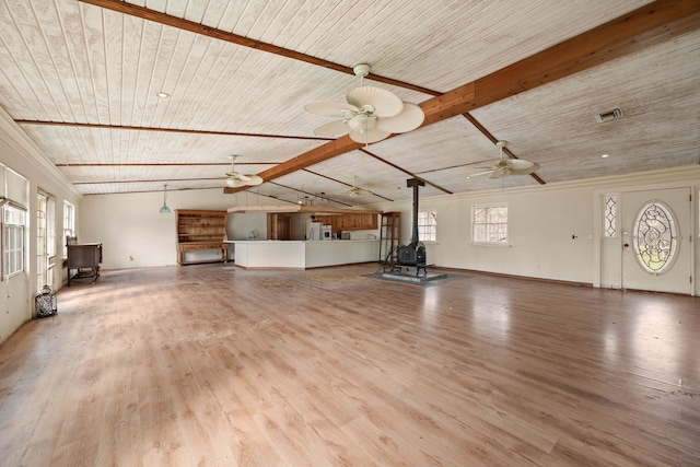 unfurnished living room with a wood stove, wooden ceiling, vaulted ceiling with beams, and wood finished floors