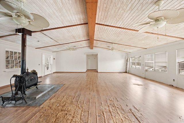 unfurnished living room featuring lofted ceiling with beams, wood-type flooring, wood ceiling, ceiling fan, and a wood stove