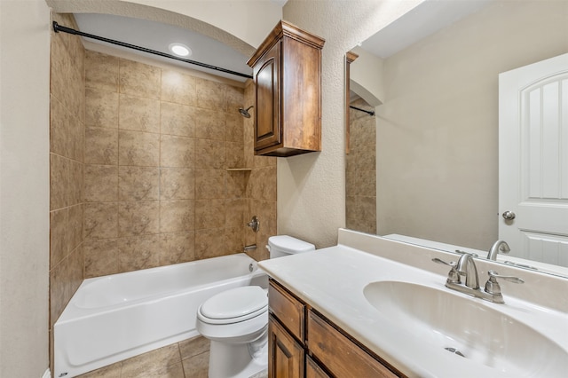 full bathroom featuring tile patterned floors, vanity, tiled shower / bath combo, and toilet