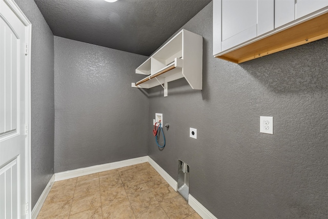 laundry room featuring washer hookup, electric dryer hookup, cabinets, and a textured ceiling