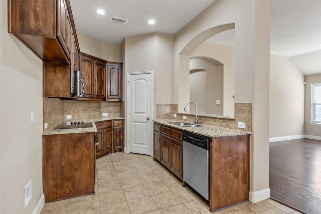 kitchen featuring light stone counters, sink, stainless steel appliances, and light wood-type flooring