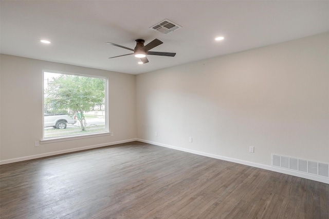 spare room with dark hardwood / wood-style flooring and ceiling fan