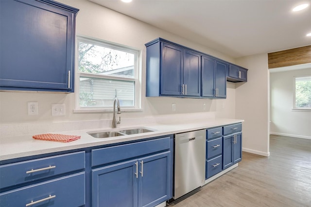 kitchen featuring stainless steel dishwasher, blue cabinetry, sink, and light wood-type flooring