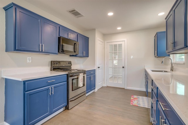 kitchen with electric stove, black microwave, a sink, and blue cabinetry