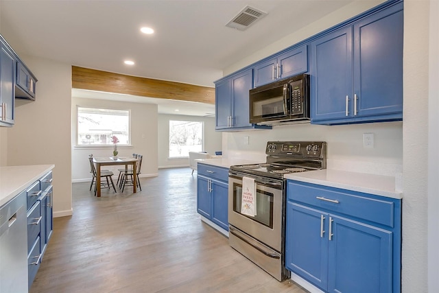 kitchen featuring blue cabinetry, visible vents, black microwave, and electric stove