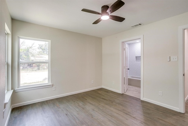 unfurnished bedroom with hardwood / wood-style floors, ensuite bath, and ceiling fan