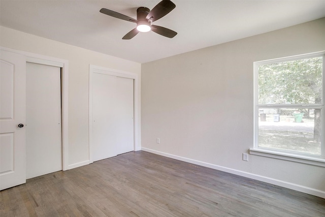 unfurnished bedroom with ceiling fan and wood-type flooring