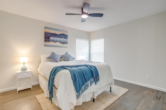 bedroom with ceiling fan, baseboards, and wood finished floors