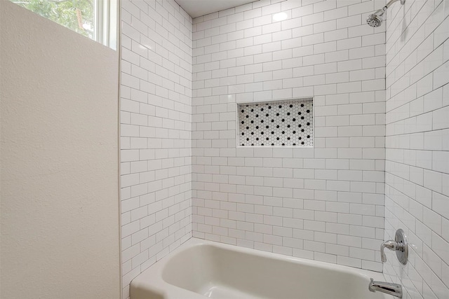 bathroom featuring tiled shower / bath