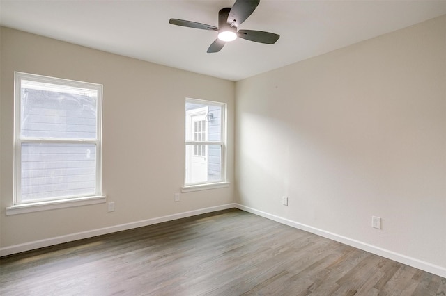 unfurnished room with ceiling fan, plenty of natural light, and wood-type flooring