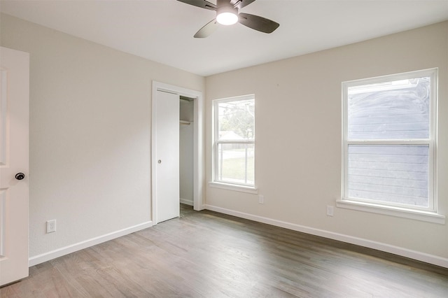 unfurnished bedroom with hardwood / wood-style flooring, ceiling fan, and a closet