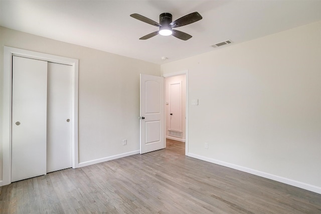 unfurnished bedroom with a closet, ceiling fan, and light wood-type flooring