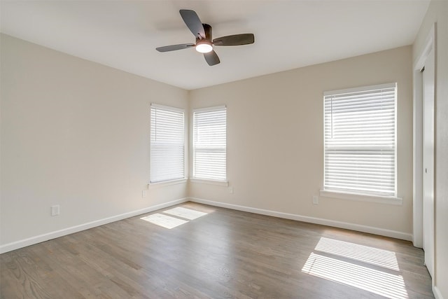 unfurnished room featuring ceiling fan, baseboards, and wood finished floors