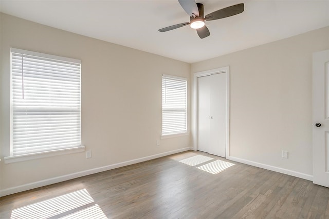 unfurnished room with baseboards, ceiling fan, and light wood-style floors