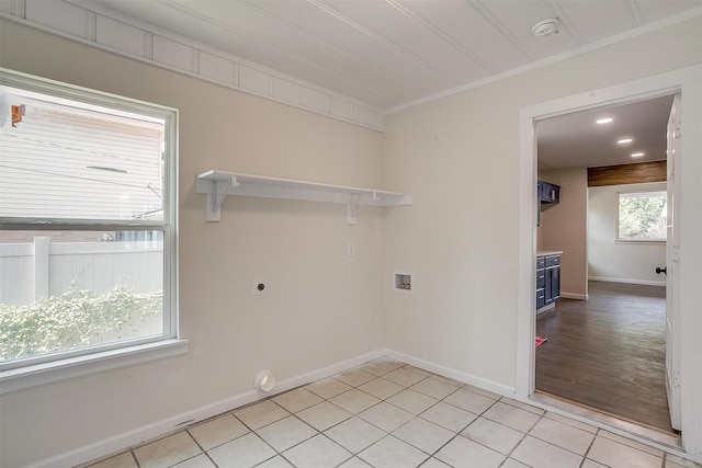 clothes washing area featuring ornamental molding, hookup for a washing machine, hookup for an electric dryer, and light tile patterned floors