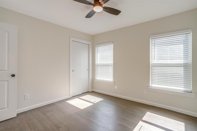 unfurnished room with ceiling fan, baseboards, and wood finished floors