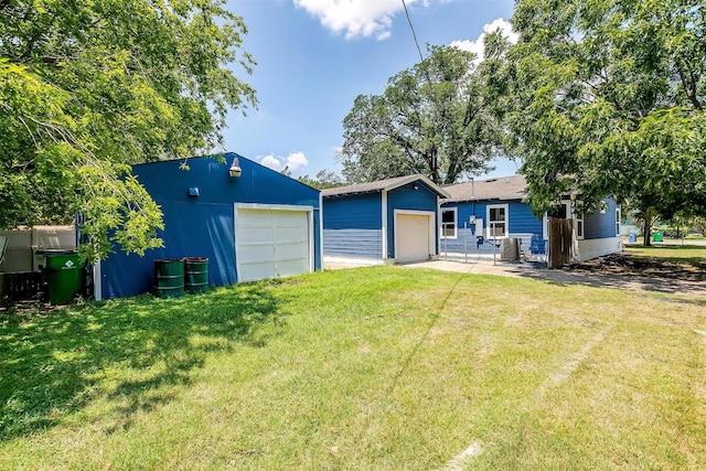 view of front of home featuring a front yard, a garage, central air condition unit, and an outdoor structure