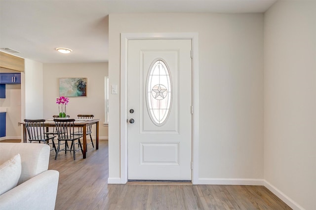 foyer entrance with wood finished floors, visible vents, and baseboards