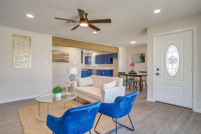 living area with light wood-type flooring, visible vents, baseboards, and recessed lighting