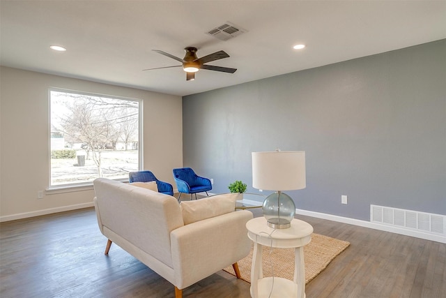 living area with visible vents, baseboards, and wood finished floors