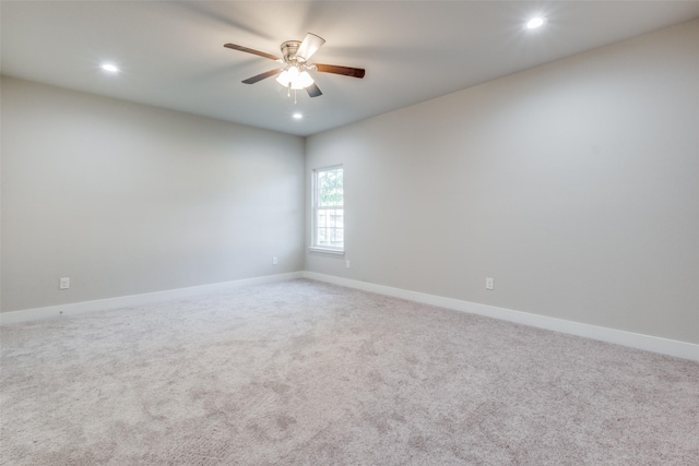 carpeted spare room with ceiling fan