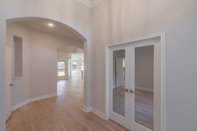 609 Keel Way, Azle, TX 76020 - hall with french doors, arched walkways, and light wood-style flooring