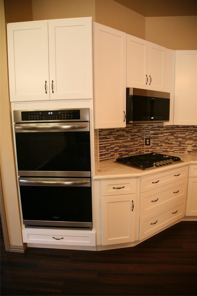 10133 Sanden, Mckinney, TX 75072 - kitchen with stainless steel appliances, dark wood-style floors, decorative backsplash, and white cabinetry