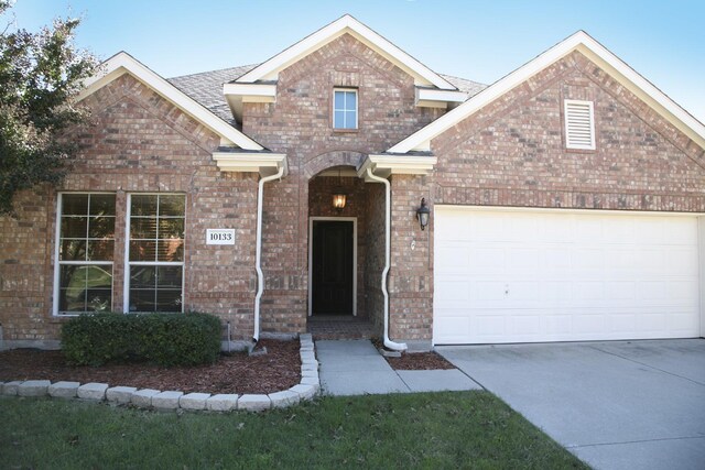 10133 Sanden, Mckinney, TX 75072 - traditional home with brick siding, a garage, and driveway