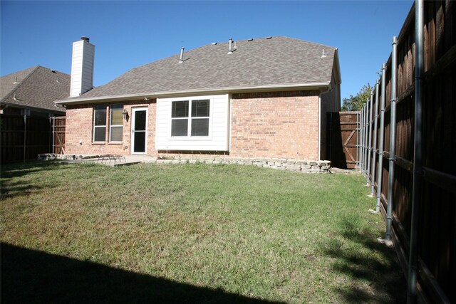 10133 Sanden, Mckinney, TX 75072 - back of property with brick siding, a fenced backyard, a lawn, and roof with shingles