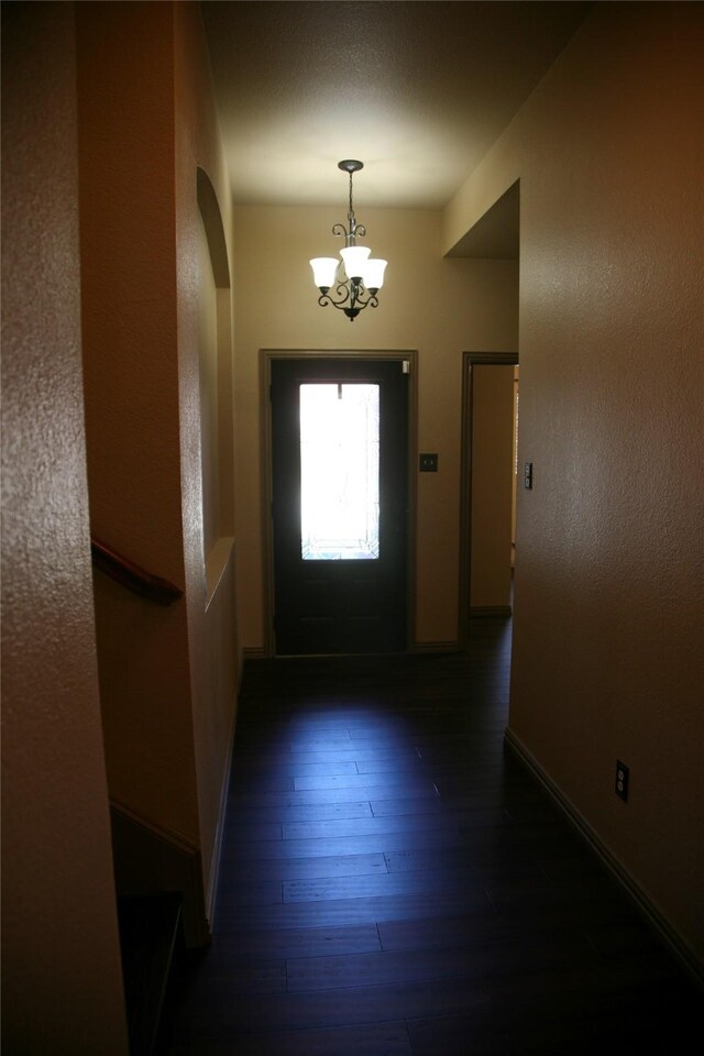 10133 Sanden, Mckinney, TX 75072 - doorway with baseboards, arched walkways, wood finished floors, and a chandelier