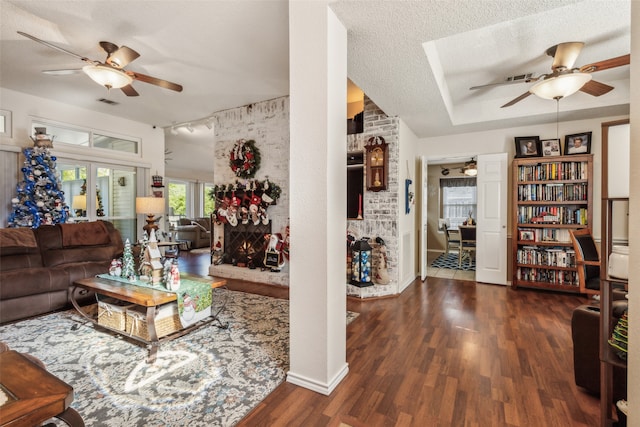 living room featuring a textured ceiling, dark hardwood / wood-style floors, and ceiling fan