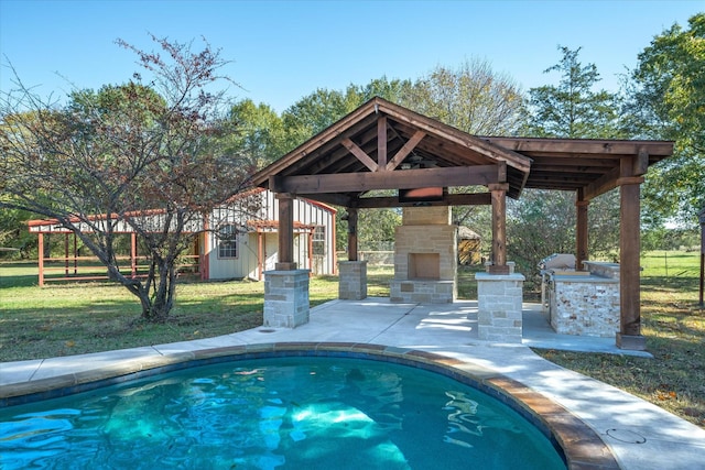 view of pool featuring a yard, a patio area, and an outdoor stone fireplace