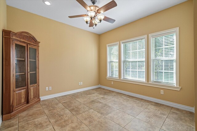 tiled empty room with a wealth of natural light, an inviting chandelier, and ornamental molding