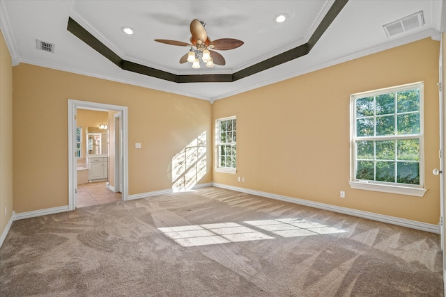 spare room featuring light carpet, ornamental molding, ceiling fan, and a healthy amount of sunlight