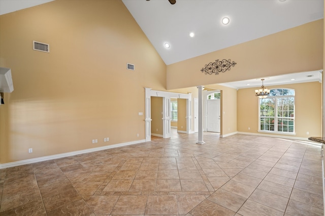 unfurnished room featuring ceiling fan with notable chandelier, high vaulted ceiling, and decorative columns