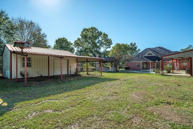 view of yard with a carport and an outbuilding